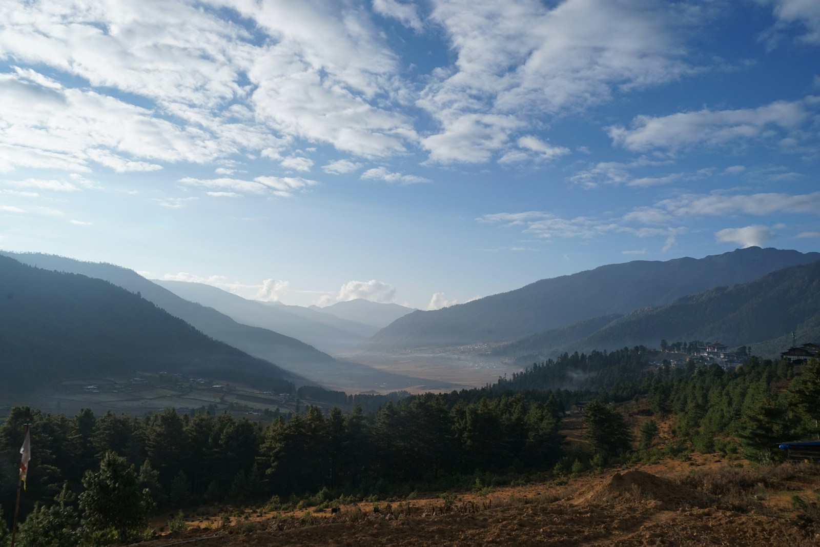 Open green valley surrounded by mountains in Bhutan